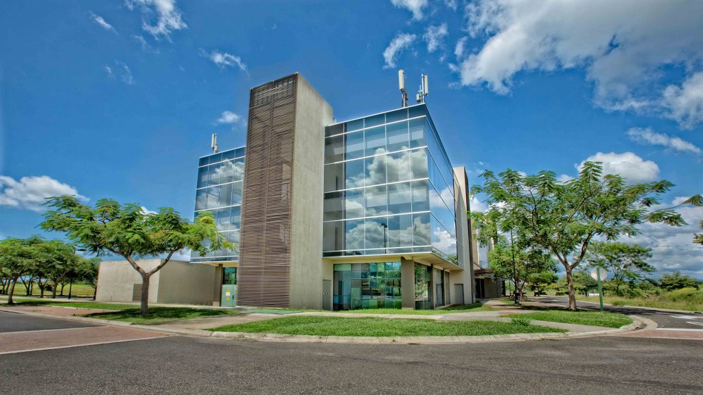 vista exterior de edificio de oficinas con arboles y cielo